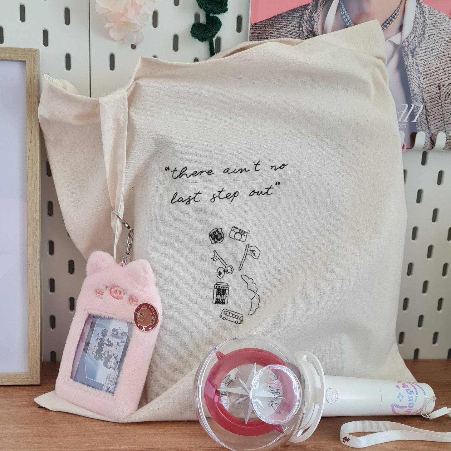 Totebag Stray Kids brodé à la main. "There ain't no last step out" est une phrase tirée des paroles de la chanson Stray Kids, du groupe éponyme. En dessous, on peut voir deviner le chiffre 8 symbolique et infini, formé grâce aux différents éléments clés de leur univers : boussole, clé, ascenseur, bus, drapeau, ailes et appareil photo. Le tout est brodé en noir sur un totebag en toile beige.
