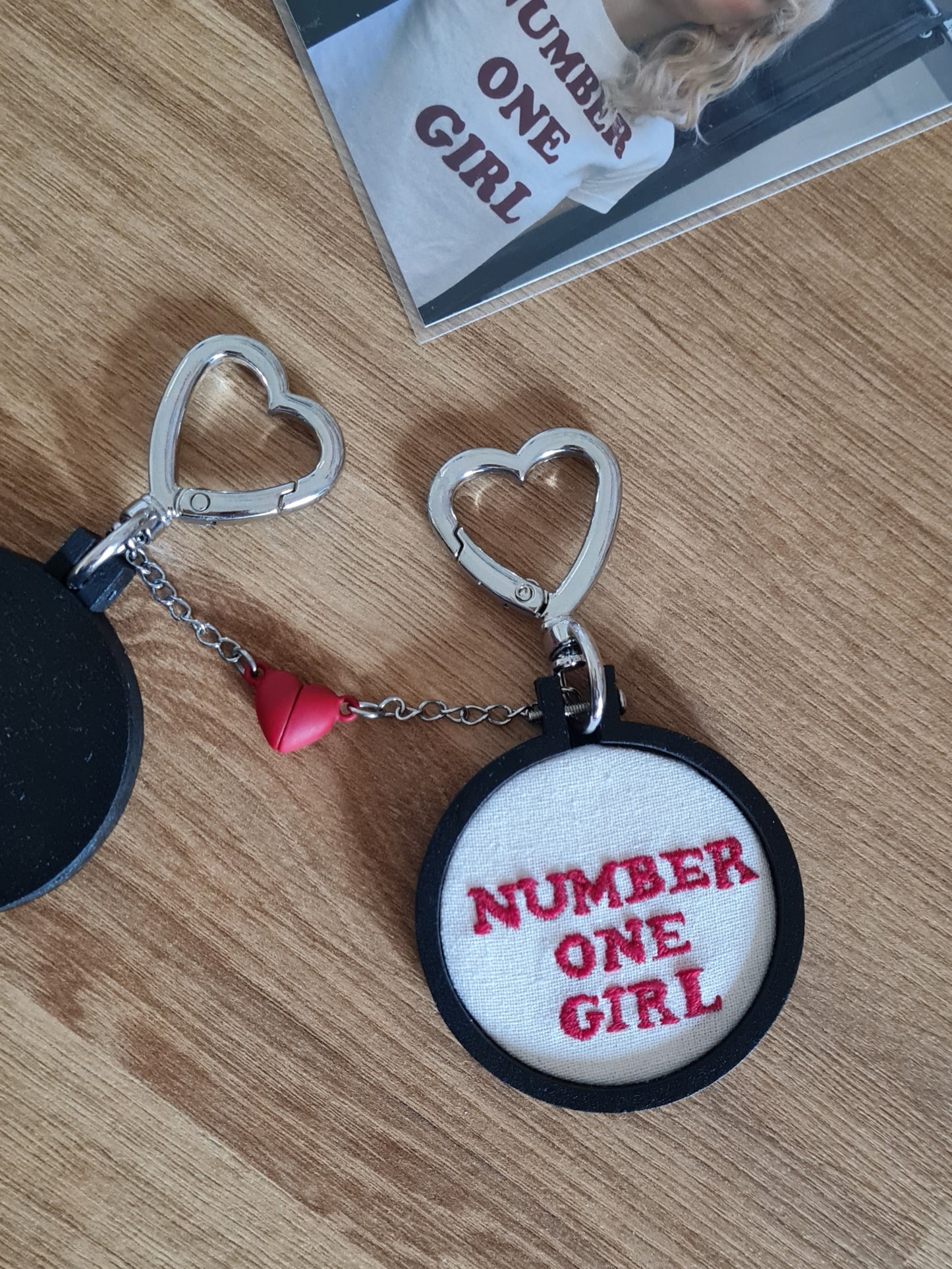 Porte-clés Number One, inspiré de la chanson Number One Girl de Rosé. Au bout de la chaîne il y a un demi-coeur brisé aimanté rouge, pour trouver votre âme sœur et compéter ce coeur ! Offrez en un exemplaire à votre bestie, votre moitié, votre Number One. Le porte-clés est déclinable en 3 versions (Number One Girl, Number One Boy, Number One Person) pour s'adapter à vous ou la personne à qui vous l'offrez. Chaque objet est peint, vernis, brodé et assemblé à la main, pour un rendu de haute qualité.